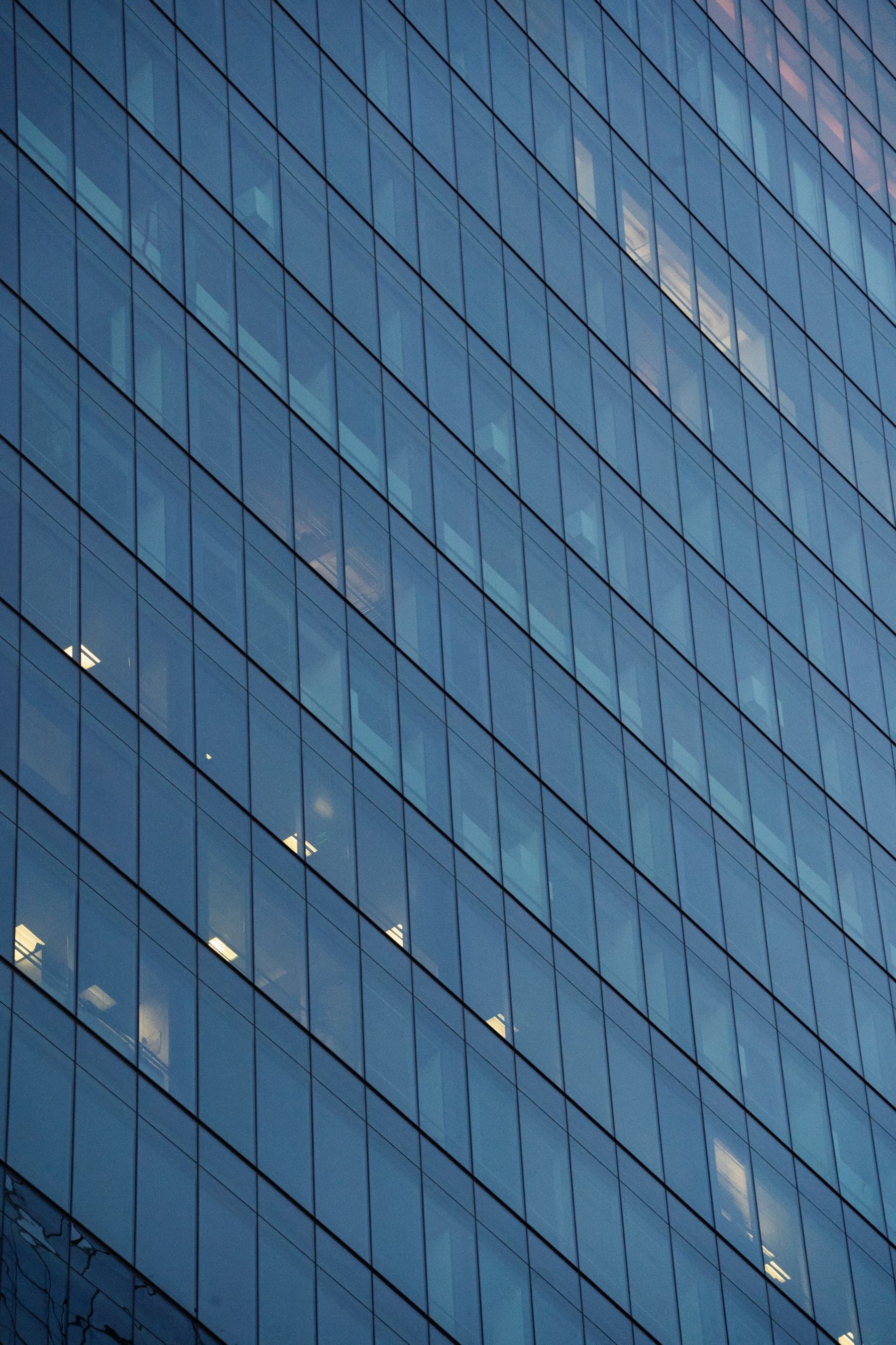 Glass facade of a corporate office building at dusk