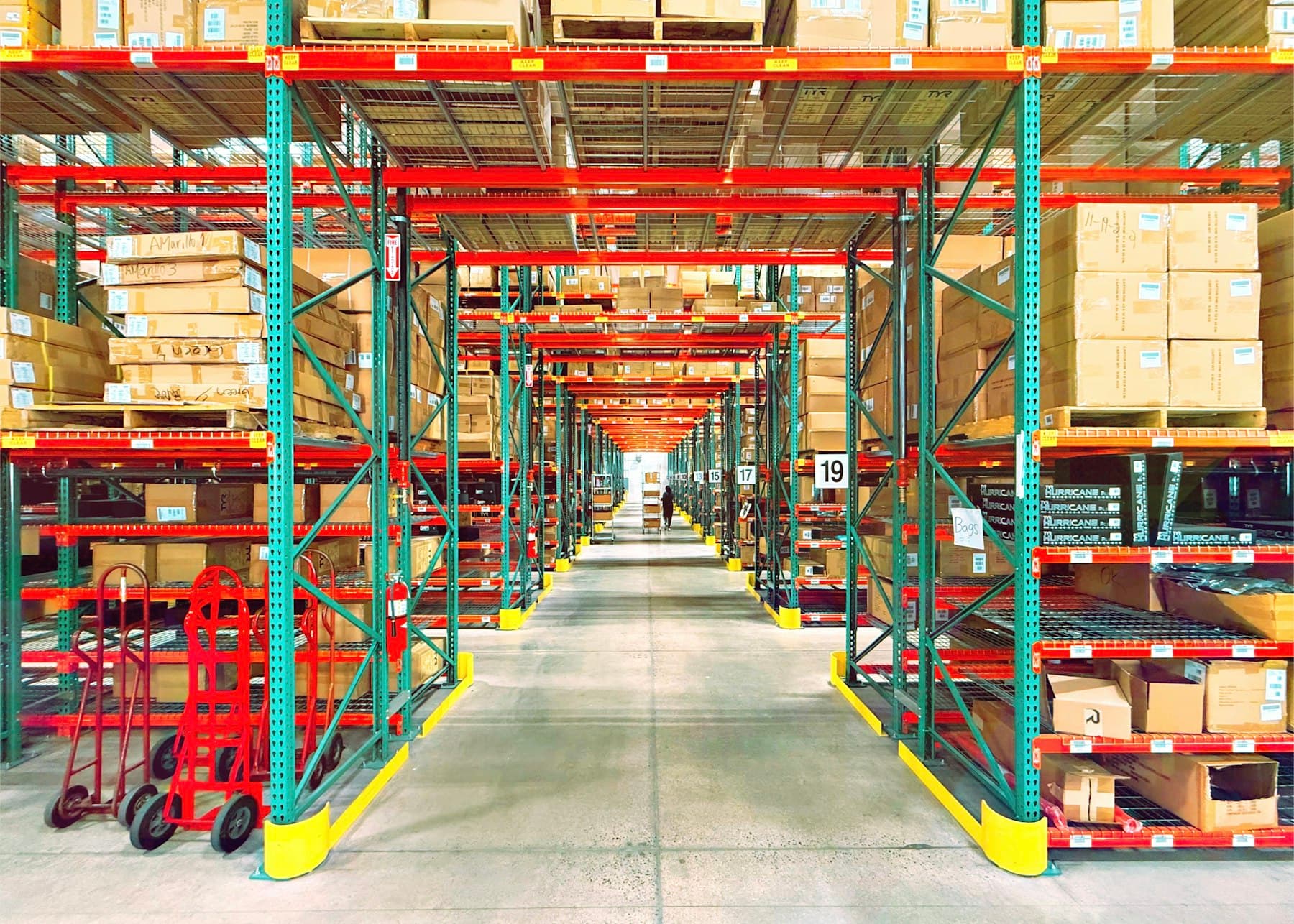 Warehouse aisle lined with industrial racking full of stock